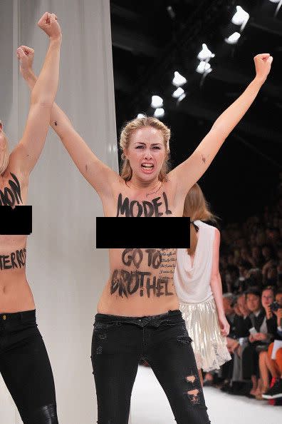 Topless FEMEN protesters crash the Nina Ricci runway.