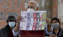 Carlos Mesa, who is running for president with the Citizen Community party, shows the ballot during general elections in La Paz, Bolivia, Sunday, Oct. 18, 2020. (AP Photo/Martin Mejia)