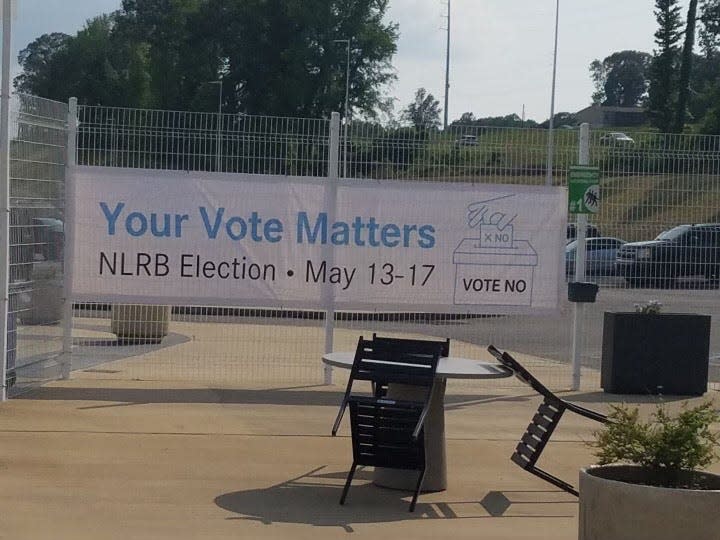 Two sides of the banner posted at the Vance Mercedes-Benz plant recently, with the one that was facing outward showing a blank vote box, while the one facing inward pictured a box marked No.