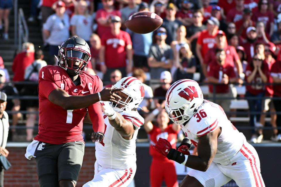 Washington State Cougars quarterback Cameron Ward (1) gets the pass away before getting hit by Wisconsin Badgers linebacker Jake Chaney (36) in the first half at Gesa Field at Martin Stadium.