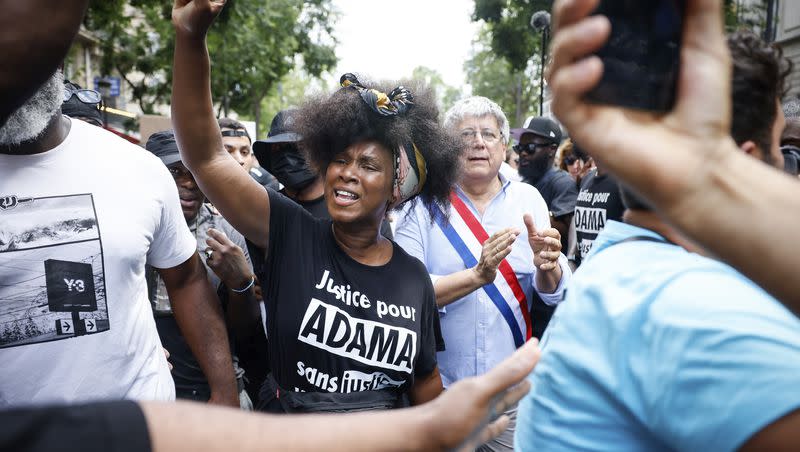 Assa Traore raises her fist during a banned protest against police violence, Saturday, July 8, 2023 in Paris. Assa Traore, whose brother Adama died in the custody of French police in 2016, is now at the forefront of a movement to wipe out what many believe to be systemic racism in policing, fight for Black rights and to challenge France’s official vision of itself as a colorblind society. At right is far-left parliament member Eric Coquerel.