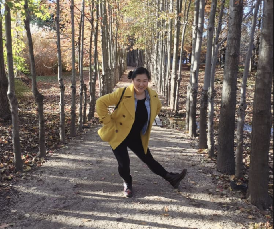 Lauren smiling an posing for a photo on a nature trail