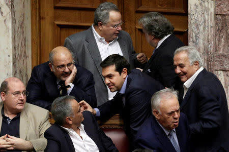 Greek Prime Minister Alexis Tsipras (C) speaks with ministers of his government after voting for an omnibus bill cutting spending on pensions, speed up privatisations and reform the electricity market, in Athens, Greece, September 27, 2016. REUTERS/Alkis Konstantinidis/File Photo