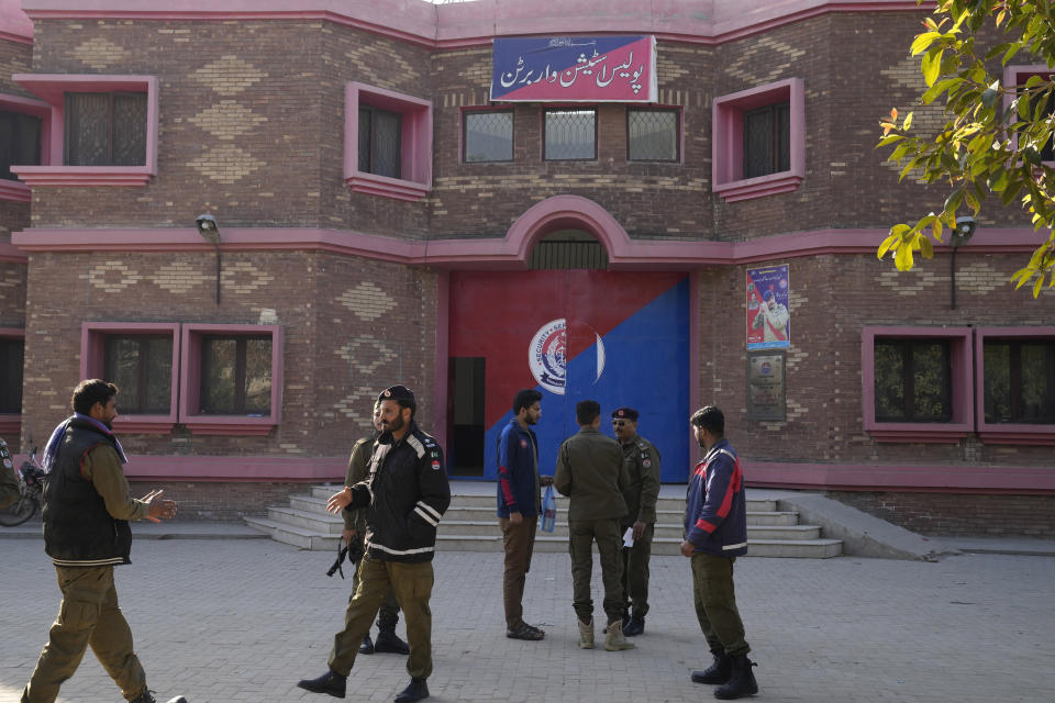 Police officers gather outside a police station, in Warburton, an area of district Nankana, Pakistan, Sunday, Feb. 12, 2023. Hundreds of Muslims descended on a police station in Pakistan's eastern Punjab province on Saturday, snatched Waris, a blasphemy suspect from his cell and took him outside and lynched him, police said. (AP Photo/K.M. Chaudary)