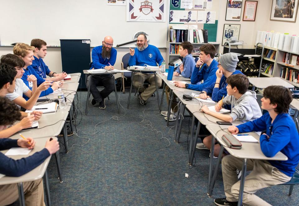 Quiz Bowl team co-head coaches Christopher Gismondi, center left, and Ben Herman read questions for team members during a practice at Detroit Catholic Central High School in Novi on Wednesday, May 24, 2023.
