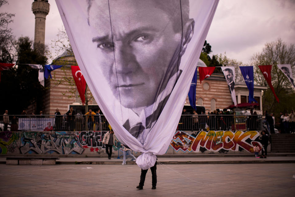 A worker removes a giant banner with the image of Mustafa Kemal Atatürk, founder of modern Turkey, at the end of a rally by Istanbul Mayor and main opposition CHP party member Ekrem Imamoglu, in Istanbul on April 26.<span class="copyright">Francisco Seco—AP</span>