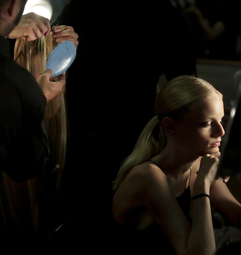 Hannegaby, right, a model from Belgium, waits for stylists to add attachments to her hair for the Jason Wu Spring Summer 2014 collection fashion show on Friday, Sept. 6, 2013 in New York. (AP Photo/Bebeto Matthews)