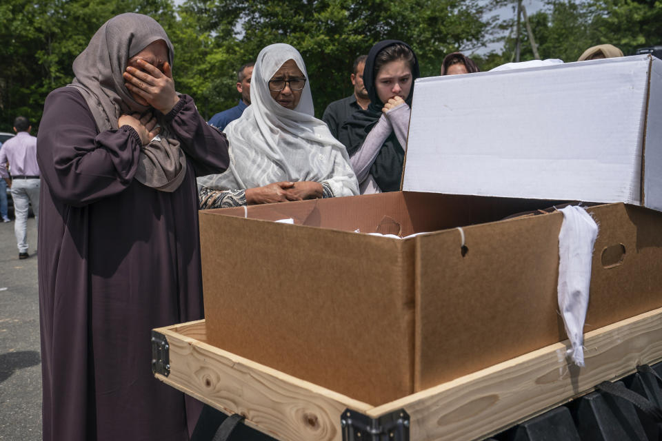 Muzhgan Ahmad Yar, left, views her husband's body during a funeral for Nasrat Ahmad Yar, 31, at the All Muslim Association of America cemetery on Saturday, July 8, 2023 in Fredericksburg, Va. Ahmad Yar, an Afghan immigrant who worked as an interpreter for the U.S. military in Afghanistan, was shot and killed on Monday, July 3, while working as a ride-share driver in Washington. (AP Photo/Nathan Howard)