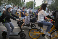 People wearing face masks to protect against the coronavirus wait at an intersection in Beijing, Wednesday, July 29, 2020. China reported more than 100 new cases of COVID-19 on Wednesday as the country continues to battle an outbreak in Xinjiang. (AP Photo/Mark Schiefelbein)