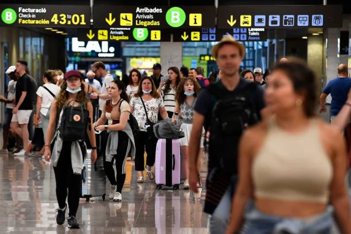 Travellers push their luggages at the Terminal 2 of El Prat airport in Barcelona (AFP via Getty Images)