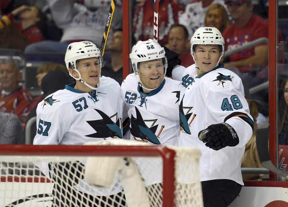 San Jose Sharks defenseman Matt Irwin (52) celebrates his goal with Tommy Wingels (57) and Tomas Hertl (48), of the Czech Republic, against the Washington Capitals during the first period of an NHL hockey game, Tuesday, Oct. 14, 2014, in Washington. (AP Photo/Nick Wass)