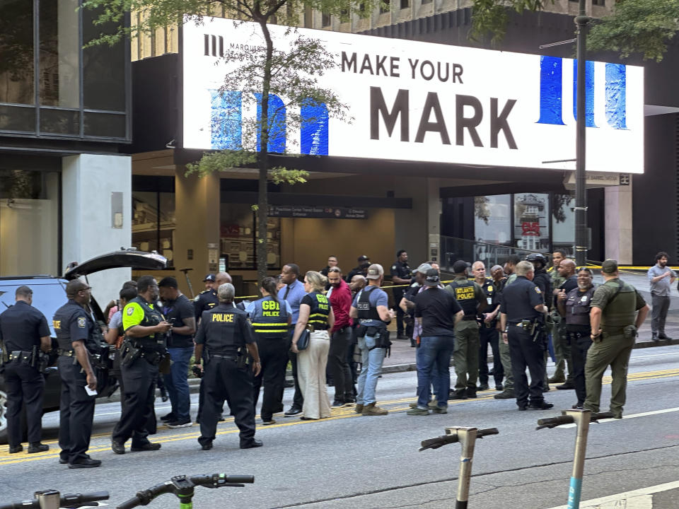 Police officers and investigators gather after a shooting at a downtown Atlanta, food court on Tuesday, June 11, 2024. (AP Photo/Jeff Amy)