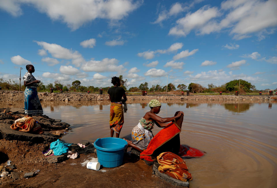 Maria Jofresse, 25, speaks with her neighbors as they wash clothes in flood water in the aftermath of Cyclone Idai, next to the village of Cheia, which means "Flood" in Portuguese, near Beira, Mozambique, April 2, 2019. (Photo: Zohra Bensemra/Reuters)  