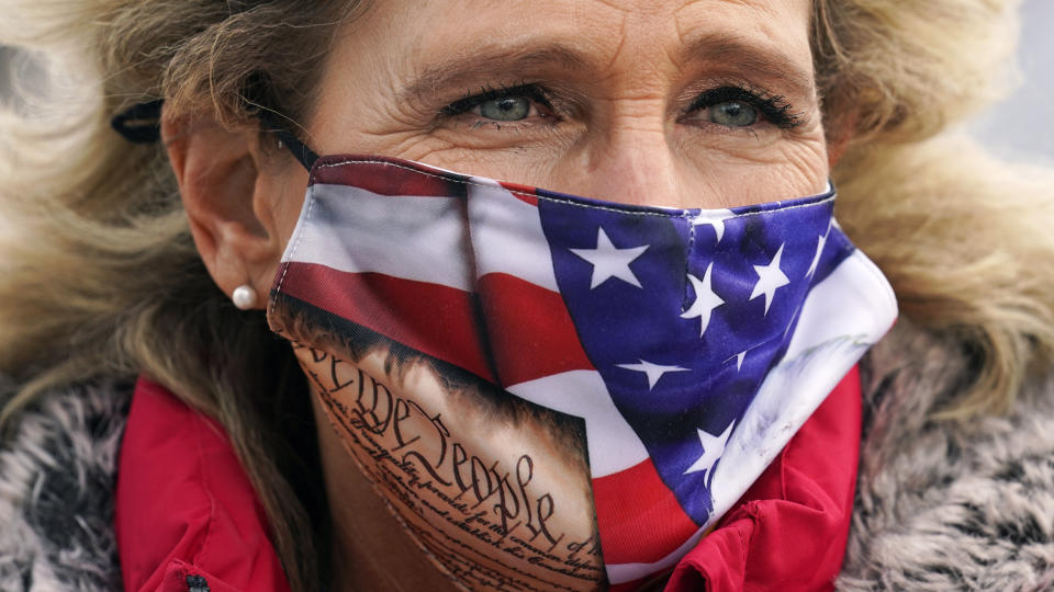 State Rep. Jeanine Notter, of Merrimack, N.H., wears a protective face covering during an outdoor meeting of the New Hampshire House of Representatives in a parking lot, due to the COVID-19 virus outbreak, at the University of New Hampshire Wednesday, Jan. 6, 2021, in Durham, N.H. (AP Photo/Charles Krupa)