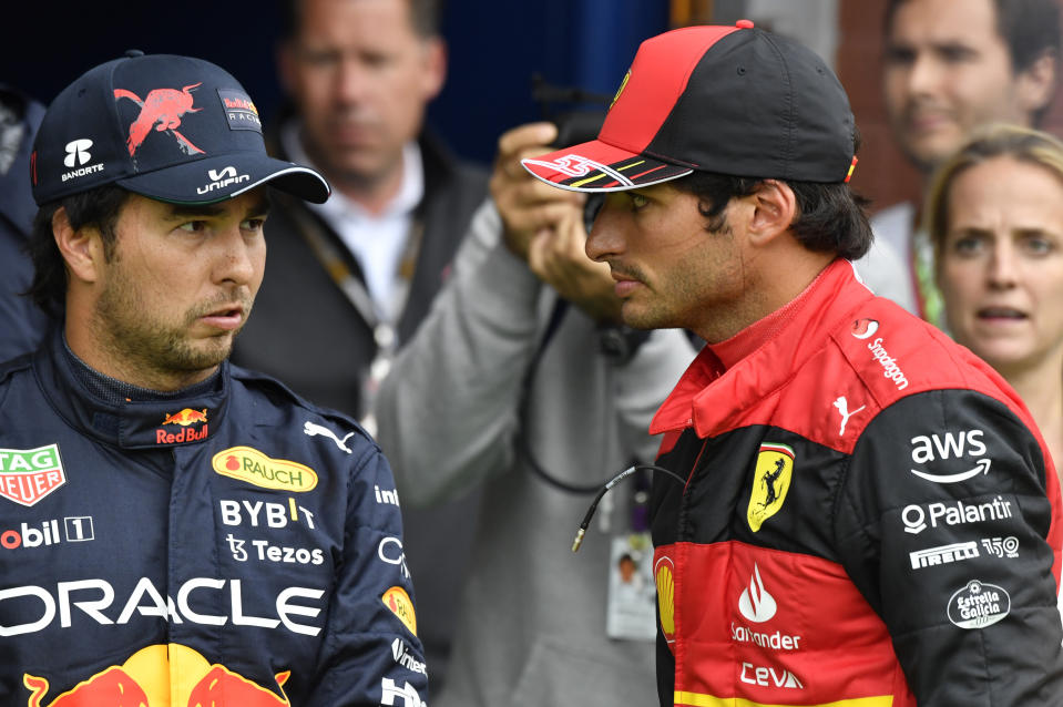 Ferrari driver Carlos Sainz of Spain, right, who clocked the second fastest time, speaks with Red Bull driver Sergio Perez of Mexico, left, who clocked the third fastest time, in the qualifying session ahead of the Formula One Grand Prix at the Spa-Francorchamps racetrack in Spa, Belgium, Saturday, Aug. 27, 2022. The Belgian Formula One Grand Prix will take place on Sunday. (AP Photo/Geert Vanden Wijngaert, Pool)
