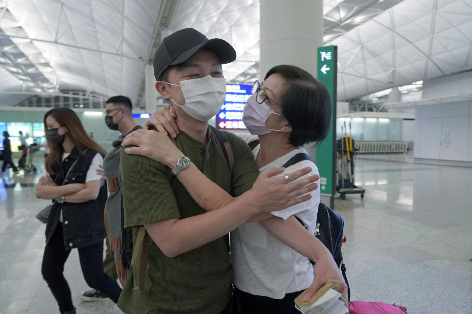 Mike Hui, left, hugs his mother before his departure to England, in Hong Kong airport on May 21, 2021. Until early April, Hui was a photojournalist for the Apple Daily, a pro-democracy newspaper that shut down following the arrest of five top editors and executives and the freezing of its assets under a national security law that China's ruling Communist Party imposed on Hong Kong as part of the crackdown. (AP Photo/Kin Cheung)