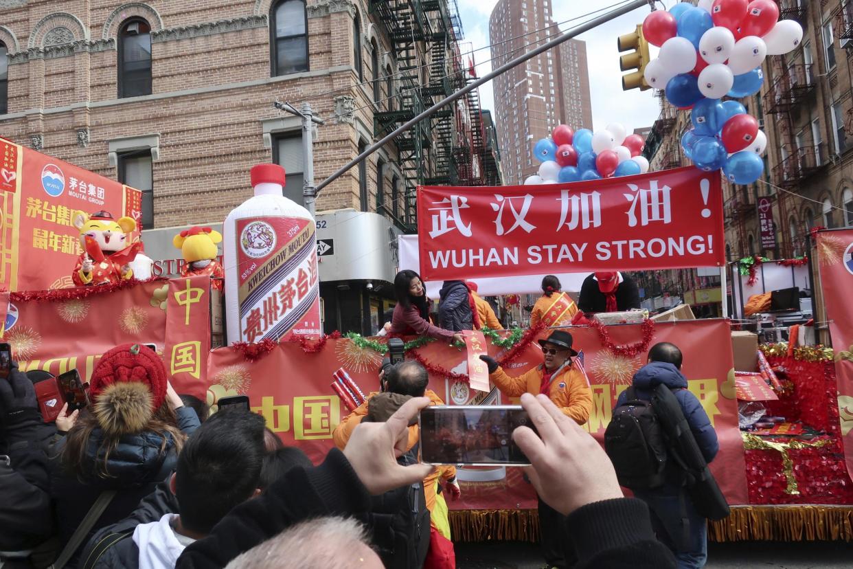 People display signs in support of Wuhan, China, at the centre of the coronavirus outbreak, during the Lunar New Year parade in New York's Chinatown in early February: (AP Photo/Ted Shaffrey)