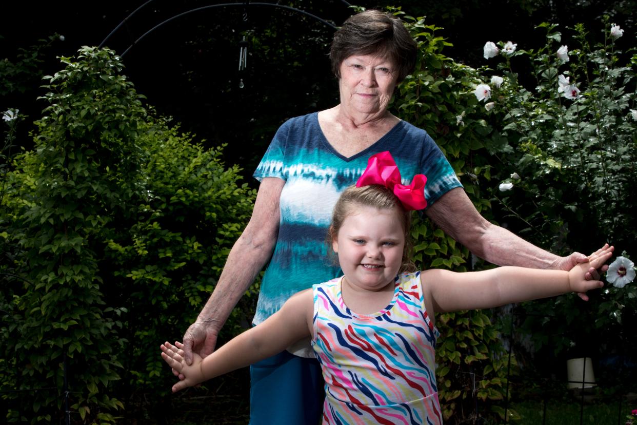 Mary Mahan, 71, stands with her granddaughter, Lyric, 4, who she is raising on Monday, Aug. 10, 2020, in Taylor Mill, Ky. Mahan is at high risk for COVID-19 because of both her age and having suffered from breast cancer twice. Due to her risk she has opted to keep Lyric home from preschool for online schooling.