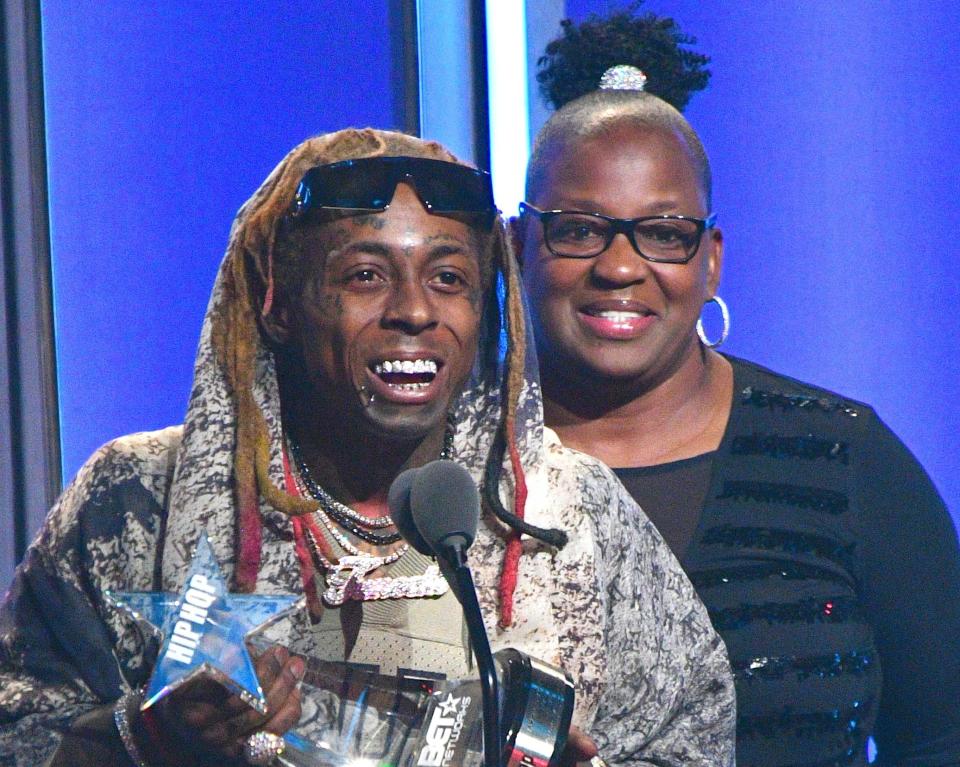 Wayne smiles while speaking on stage with his mom