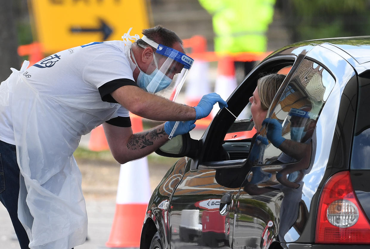 A medical worker takes a swab at a drive-in coronavirus testing facility at the Chessington World of Adventures Resort in south west London, as the UK continues in lockdown to help curb the spread of the coronavirus.