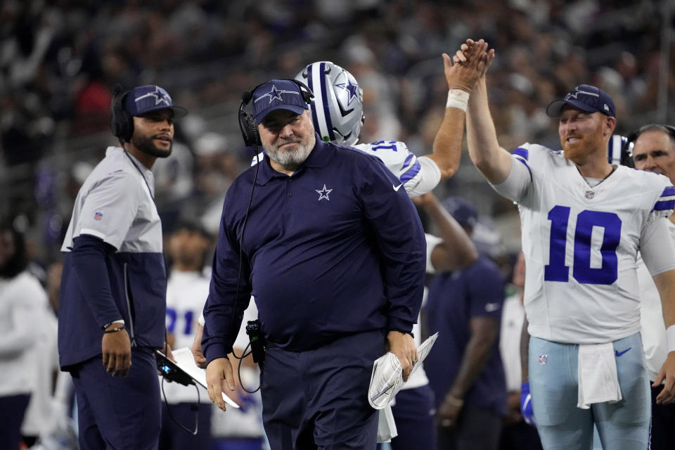 Dallas Cowboys head coach Mike McCarthy, center, smiles as quarterback Dak Prescott, left rear, quarterback Cooper Rush (10) and others celebrate a score against the Las Vegas Raiders in the first half of a preseason NFL football game in Arlington, Texas, Saturday, Aug. 26, 2023. (AP Photo/Sam Hodde)