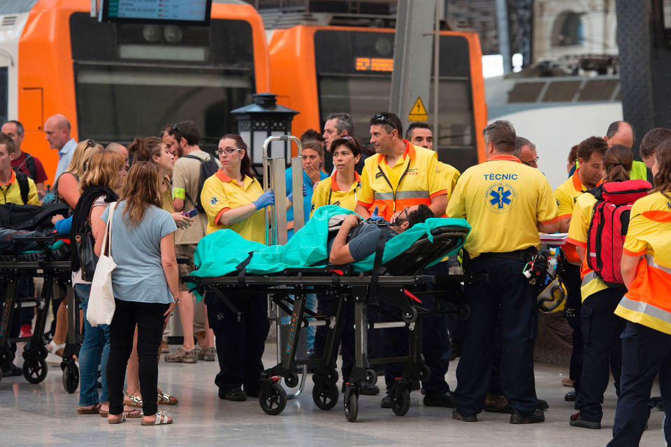 <p>A man lies on a stratcher as emergency personel gather on a platform beside a train at Estacio de Franca (Franca station) in central Barcelona on July 28, 2017 after the regional train appears to have hit the end of the track inside the station injuring dozens of people. (Photo: Josep Lagos/AFP/Getty Images) </p>