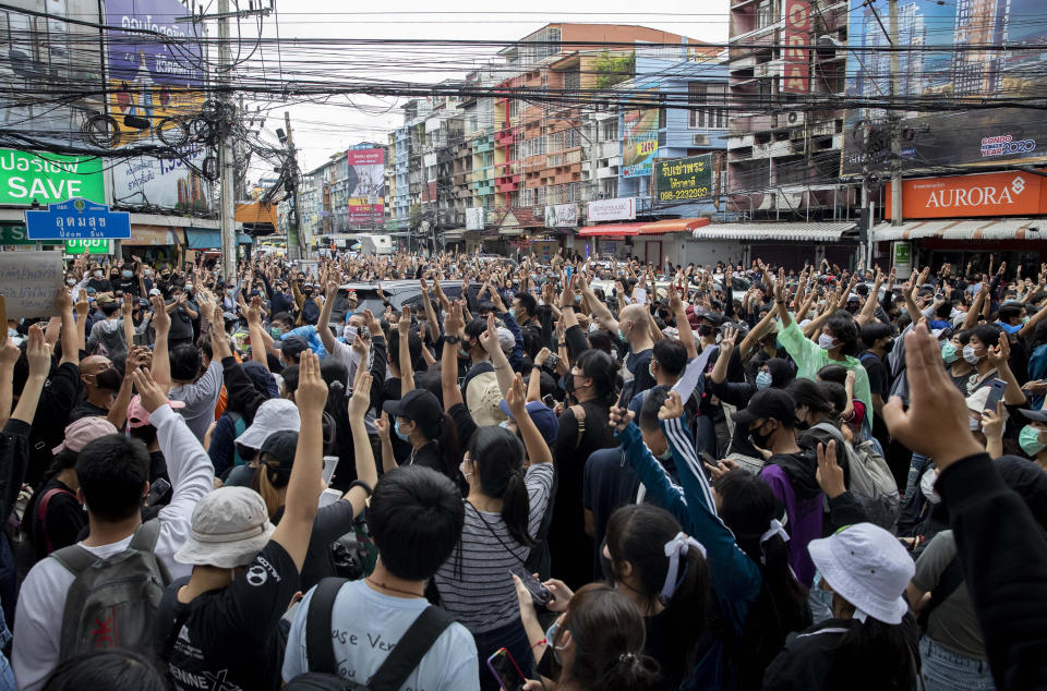 Pro-democracy protesters flash three-fingered salute during a protest in Udom Suk, suburbs of Bangkok, Thailand, Saturday, Oct. 17, 2020. The authorities in Bangkok shut down mass transit systems and set up roadblocks Saturday as Thailand’s capital faced a fourth straight day of determined anti-government protests. (AP Photo/Gemunu Amarasinghe)