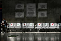 A man wearing mask sits on an airport bench a seat apart in line with social distancing rules at Cyprus' main airport in Larnaca, on Tuesday, June 9, 2020. Cyprus re-opened its airports on Tuesday to a limited number of countries after nearly three months of commercial air traffic as a result of a strict lockdown aimed at staving off the spread of COVID-19. (AP Photo/Petros Karadjias)