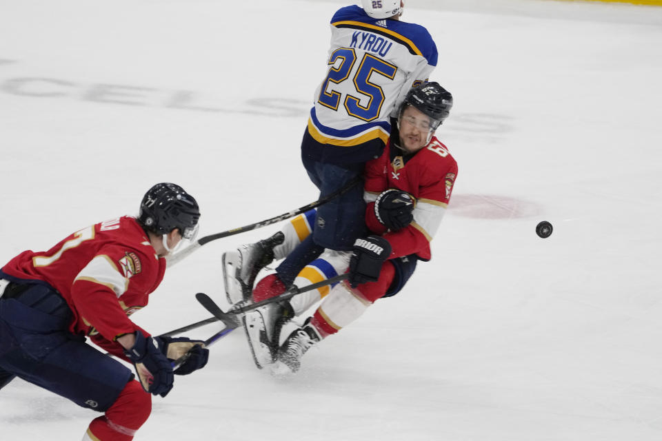 St. Louis Blues center Jordan Kyrou (25) and Florida Panthers defenseman Brandon Montour (62) collide during the first period of an NHL hockey game, Thursday, Dec. 21, 2023, in Sunrise, Fla. (AP Photo/Marta Lavandier)