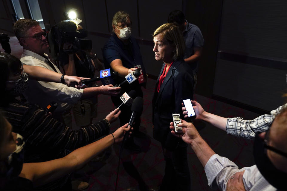 Iowa Gov. Kim Reynolds speaks to reporters following a news conference, Thursday, Aug. 19, 2021, in West Des Moines, Iowa. Reynolds lashed out at President Joe Biden Thursday after he ordered his education secretary to explore possible legal action against states that have blocked school mask mandates and other public health measures meant to protect students against COVID-19. Reynolds, a Republican, has signed a bill into law that prohibits school officials from requiring masks, raising concerns as delta variant virus cases climb across the state and schools resume classes soon. (AP Photo/Charlie Neibergall)