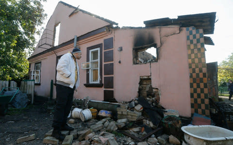 A local man inspects a damaged building in Kalynivka on Wednesday morning - Credit: SERGEY DOLZHENKO/EPA