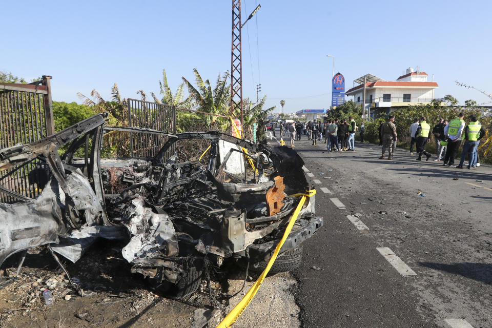 Lebanese soldiers and Civil defense workers gather next to a damaged car in the southern town of Bazouriyeh, Lebanon, Saturday, Jan. 20, 2024. An Israeli drone strike on the car near the Lebanese southern port city of Tyre killed two people, the state-run National News Agency reported. (AP Photo/Mohammad Zaatari)