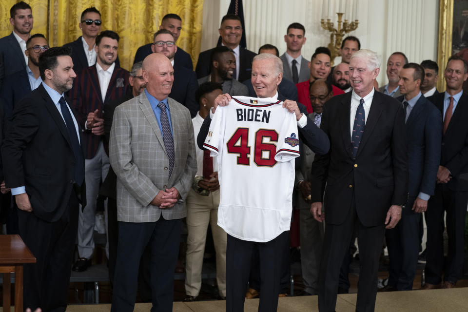 President Joe Biden holds up a jersey during an event celebrating the 2021 World Series champion Atlanta Braves, in the East Room of the White House, Monday, Sept. 26, 2022, in Washington. From left, Braves President of Baseball Operations Alex Anthopoulos, manager Brian Snitker, Biden, and Braves President and CEO Terry McGuirk. (AP Photo/Evan Vucci)