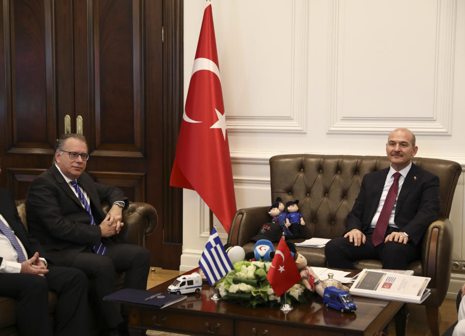 Turkey's Interior Minister Suleyman Soylu, right, meet with George Koumoutsakos, left, Greece's Alternate Minister for immigration policy in the Ministry of Citizen's Protection of Greece, prior to their meeting in Ankara, Turkey, Thursday, Oct. 3, 2019. Soylu is scheduled to have a meeting later on Thursday with his French and German counterparts on the EU-Turkey migration agreement and supporting EU-member Greece in coping with migrant arrivals. (AP Photo/Ali Unal)