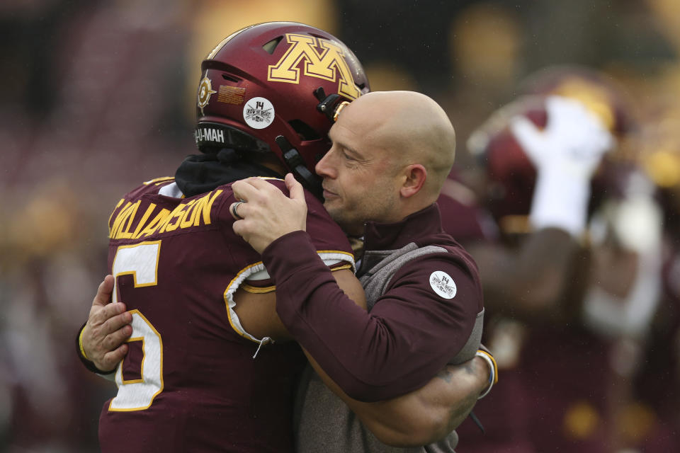 Minnesota head coach P.J. Fleck hugs defensive back Chris Williamson (6) during an NCAA college football game against Wisconsin, Saturday, Nov. 30, 2019, in Minneapolis. Wisconsin won 38-17. (AP Photo/Stacy Bengs)