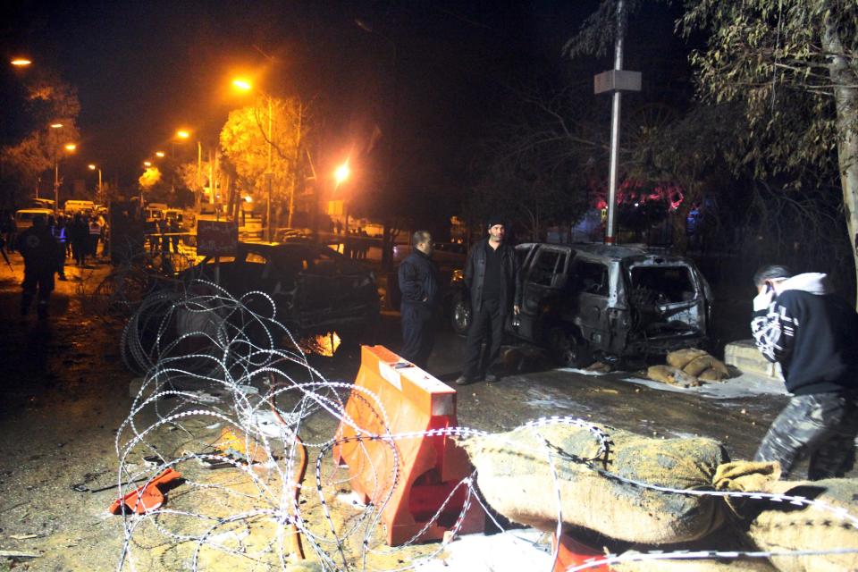 Lebanese army and citizens gather at the site of an explosion, in the predominately Shiite town of Hermel, about 10 miles (16 kilometers) from the Syrian border in northeast Lebanon, Saturday, Feb. 22, 2014. A suicide attacker blew himself up at an army checkpoint after troops tried to search his car Saturday, killing and wounding a number of people including soldiers in the latest blast linked to Syria's civil war, a senior military official and the state news agency said. (AP Photo)