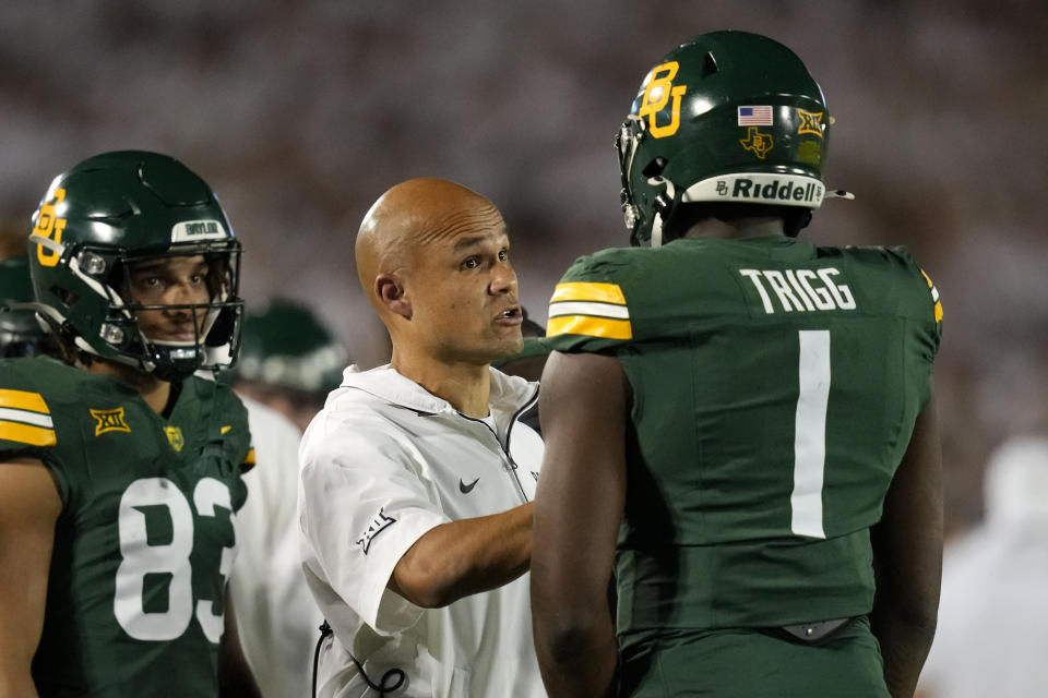 Baylor head coach Dave Aranda, center, talks with tight end Michael Trigg (1) during the first half of an NCAA college football game against Iowa State, Saturday, Oct. 5, 2024, in Ames, Iowa. (AP Photo/Charlie Neibergall)