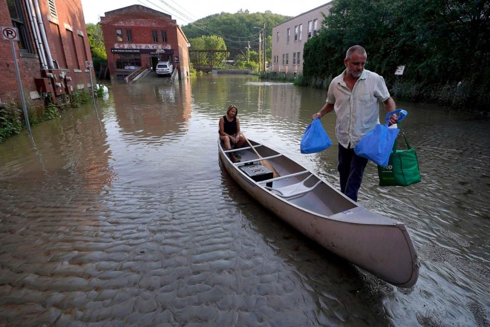 PHOTO: Jodi Kelly, seated center, practice manager at Stonecliff Veterinary Surgical Center, behind, and her husband Veterinarian Dan Kelly, right, use a canoe to remove surgical supplies from the flood damaged center, July 11, 2023, in Montpelier, Vt. (Steven Senne/AP)