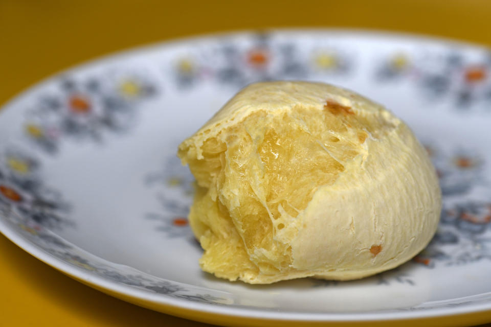 A single piece of cheese on a patterned plate