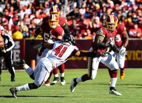 Washington Redskins running back Adrian Peterson (26) rushes the ball against Atlanta Falcons defensive back Sharrod Neasman (41) - Credit: Brad Mills/USA Today