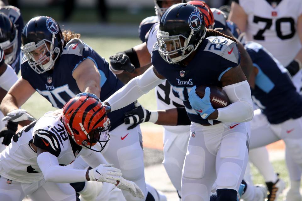 Tennessee Titans running back Derrick Henry (22) stuff arms Cincinnati Bengals cornerback LeShaun Sims (38) on a run during the first quarter of a Week 8 NFL football game, Sunday, Nov. 1, 2020, at Paul Brown Stadium in Cincinnati. 