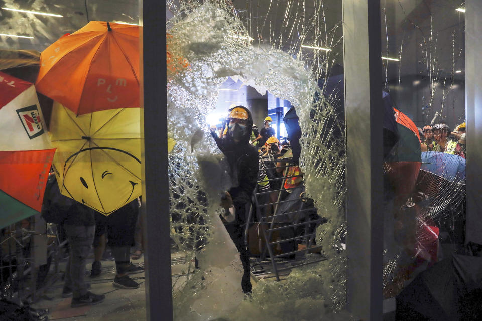 In this July 1, 2019, file photo, a protester breaks a glass wall as they try to enter the Legislative Council in Hong Kong. A national security law enacted in 2020 and COVID-19 restrictions have stifled major protests in Hong Kong including an annual march on July 1. (AP Photo/Kin Cheung, File)