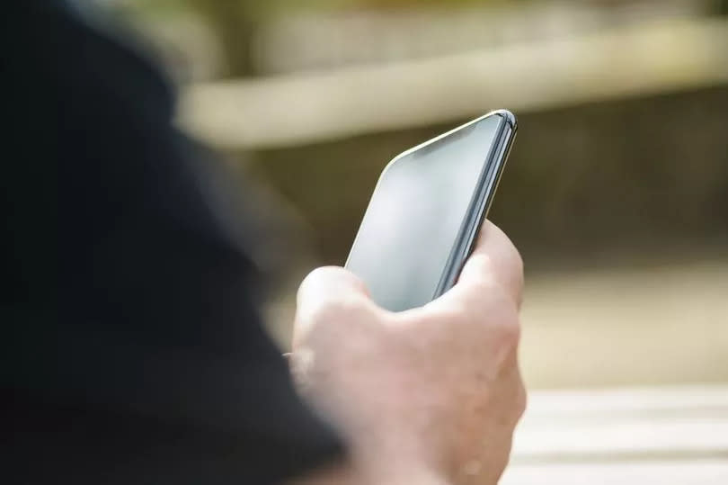 An image of a person holding a mobile phone.