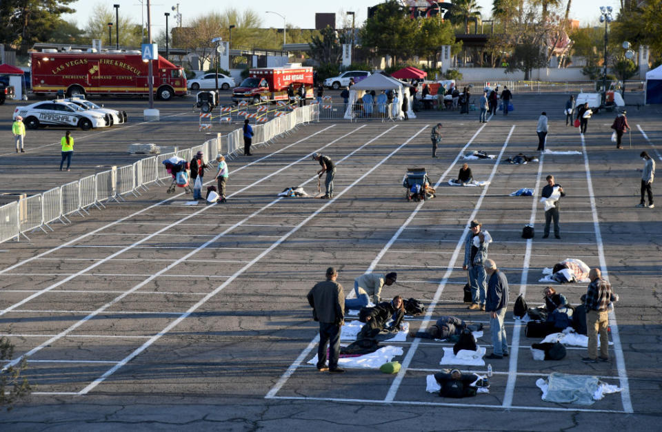 Homeless people sit in painted squares at a Las Vegas carpark.