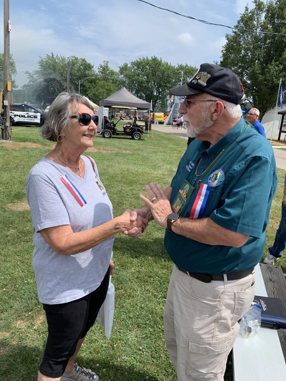 Sharon Herrera of Monroe, an Army veteran, accepts a Vietnam Veteran lapel pin from John H. Riling III, president of the Michigan State Council of the Vietnam Veterans of America and the guest speaker at the annual Veterans Day program held Monday at the Monroe County Fair.
