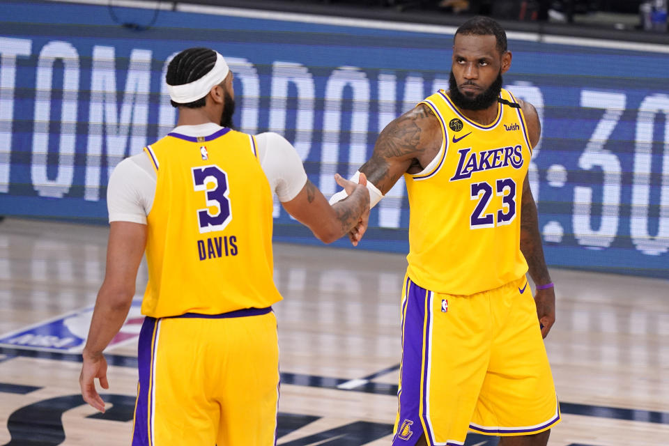 Los Angeles Lakers' Anthony Davis (3) and LeBron James (23) shake hands in the final moments of their 114-108 win over the Denver Nuggets in an NBA conference final playoff basketball game Thursday, Sept. 24, 2020, in Lake Buena Vista, Fla. (AP Photo/Mark J. Terrill)