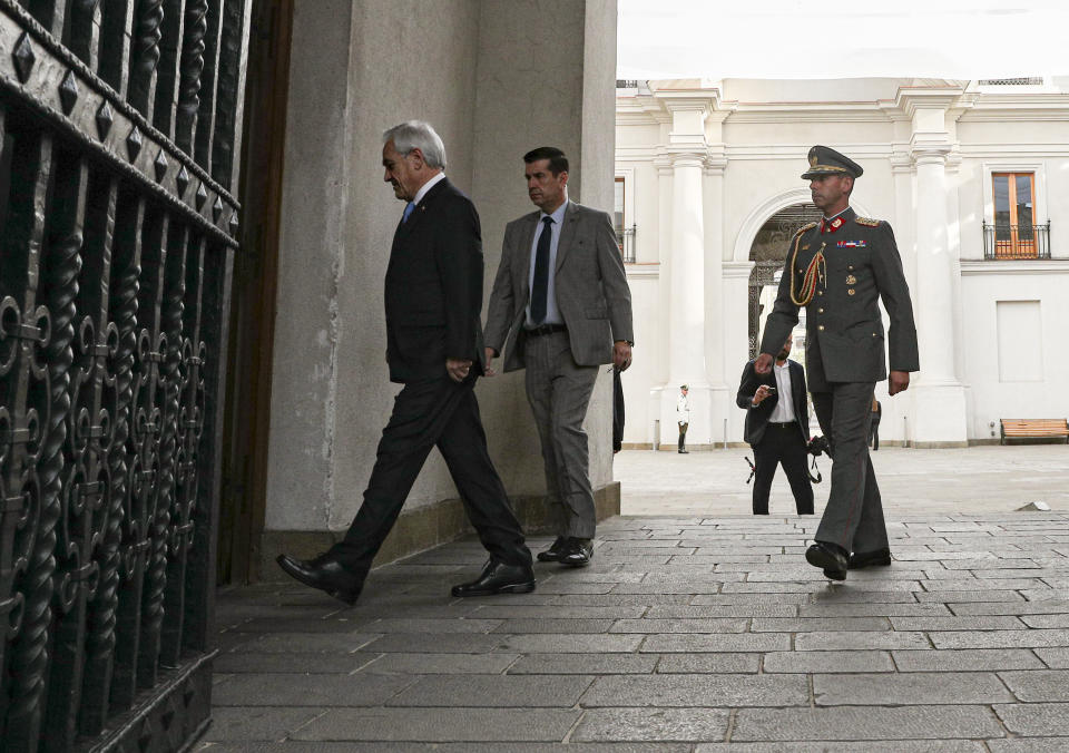 Chile's President Sebastian Pinera arrives to La Moneda presidential palace in Santiago, Chile, Monday, Nov. 11, 2019. The government announced Sunday it has agreed to start the process to write a new constitution for the country, one of the most repeated demands of protesters who have taken to the streets in often violent demonstrations in recent weeks. (AP Photo/Esteban Felix)