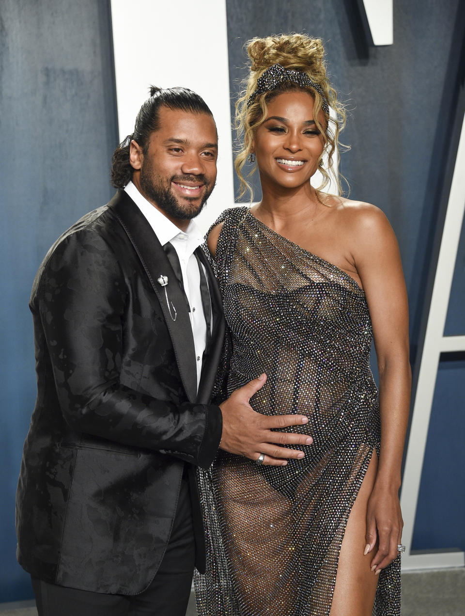 FILE - NFL quarterback Russell Wilson, left, and his pregnant wife Ciara arrive at the Vanity Fair Oscar Party in Beverly Hills, Calif. on Feb. 9, 2020. Wilson and his pop star wife Ciara are now parents to a baby boy. The couple announced Friday the birth of their son named Win Harrison Wilson on Instagram. (Photo by Evan Agostini/Invision/AP, File)