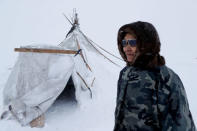 A herder of the agricultural cooperative organisation "Erv" stands in front of a traditional tent at a reindeer camping ground, about 250 km north of Naryan-Mar, in Nenets Autonomous District, Russia, March 8, 2018. REUTERS/Sergei Karpukhin