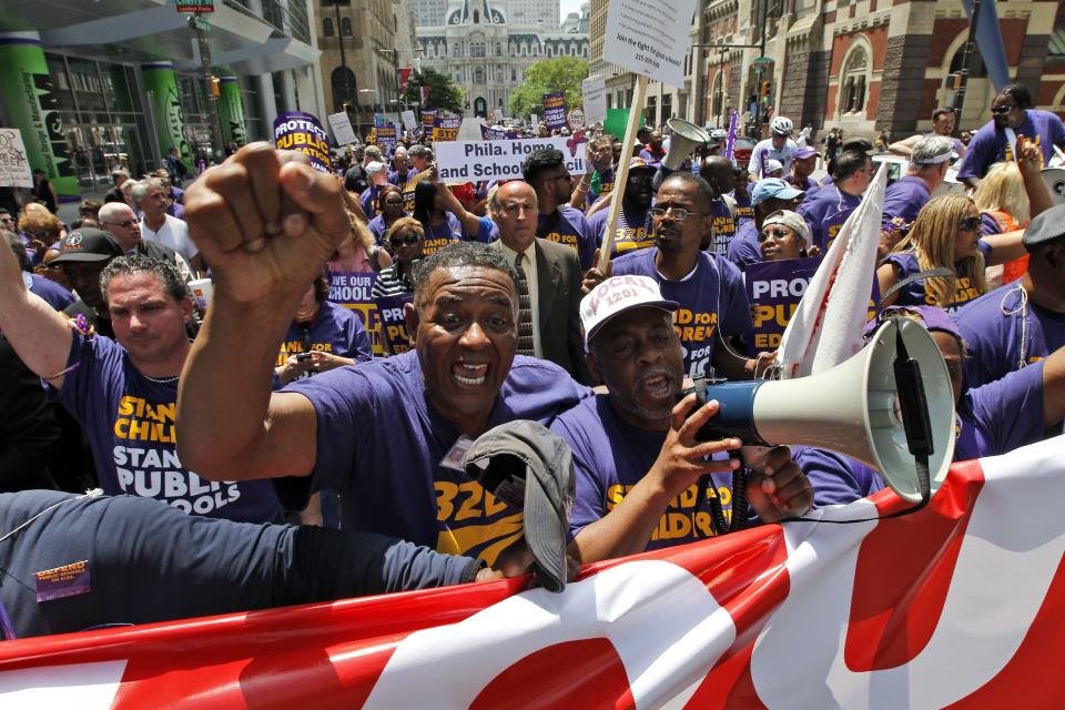 Protestors walk on Broad Street with City Hall behind them, during a protest of Pennsylvania Gov. Tom Corbett's proposed cuts to the education budget Wednesday, May 23, 2012 in Philadelphia. Protesters statewide took to the streets on Wednesday, and a total of 25 people were arrested during massive demonstrations in Philadelphia and Pittsburgh. Organizers said similar rallies were scheduled in cities including Doylestown, Hollidaysburg, Bethlehem, Hazleton and Greensburg. (AP Photo/Alex Brandon)